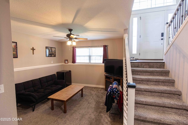 carpeted living area featuring stairway, ceiling fan, and a textured ceiling
