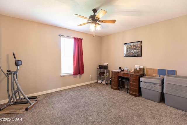 carpeted office space featuring baseboards and a ceiling fan