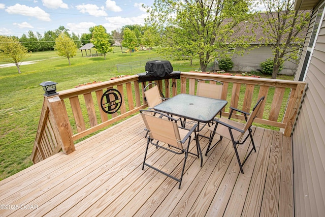 wooden terrace with a yard and outdoor dining space