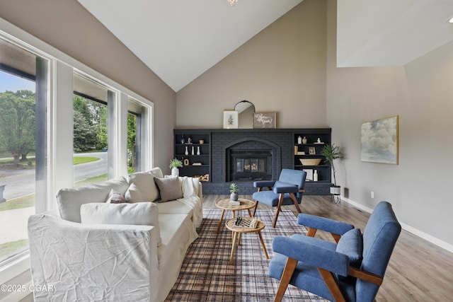 1214 Bramar Dr, Joplin, MO 64804 - living room featuring wood finished floors, a fireplace, baseboards, and high vaulted ceiling