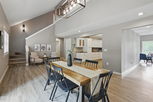 1214 Bramar Dr, Joplin, MO 64804 - dining room with stairway, light wood-style flooring, baseboards, recessed lighting, and a towering ceiling