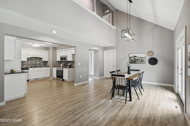 1214 Bramar Dr, Joplin, MO 64804 - dining room featuring light wood-style floors, baseboards, high vaulted ceiling, and recessed lighting