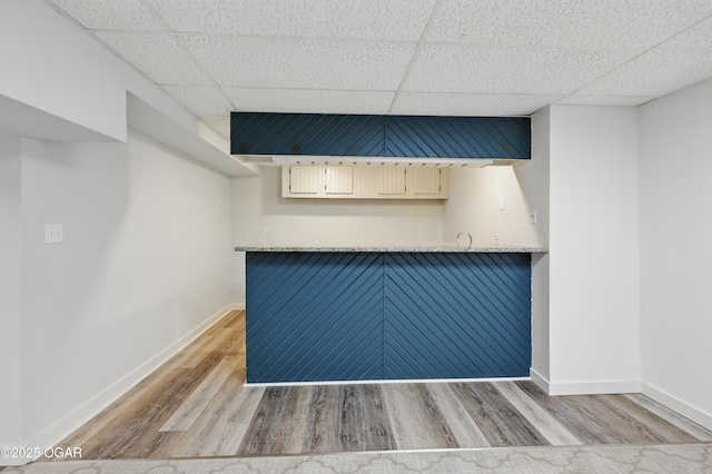 1214 Bramar Dr, Joplin, MO 64804 - unfurnished room featuring a drop ceiling, light wood-style flooring, and baseboards