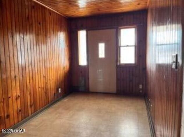 interior space with light floors, wooden walls, and a wealth of natural light