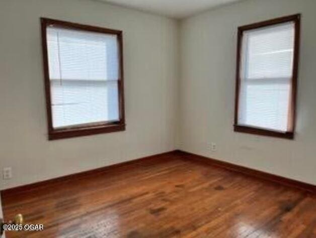 empty room featuring baseboards and wood finished floors
