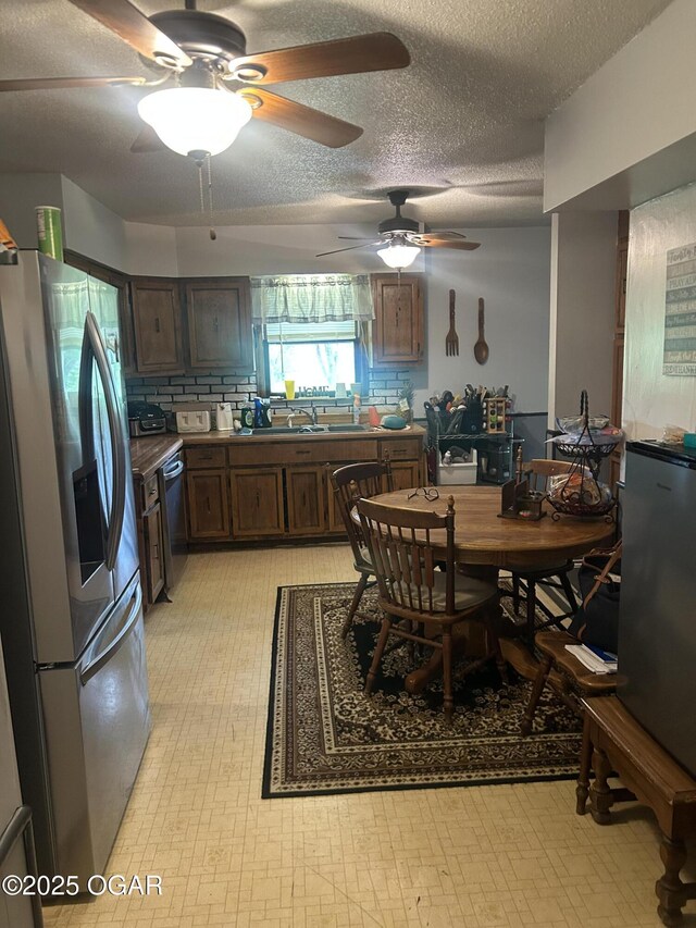 dining space featuring light floors, a textured ceiling, and a ceiling fan