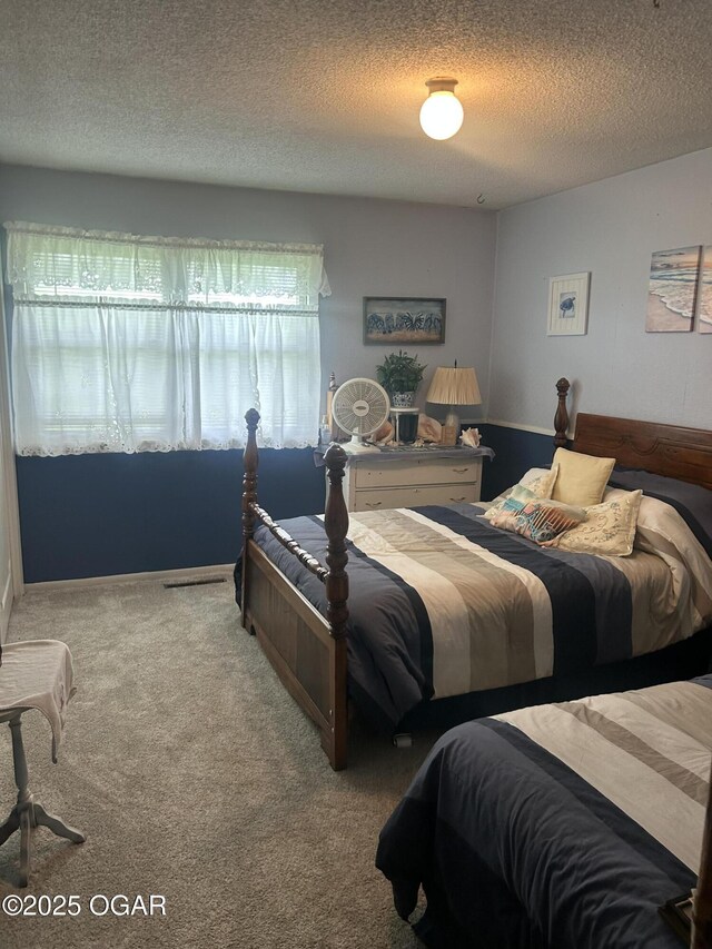 bedroom featuring carpet flooring and a textured ceiling