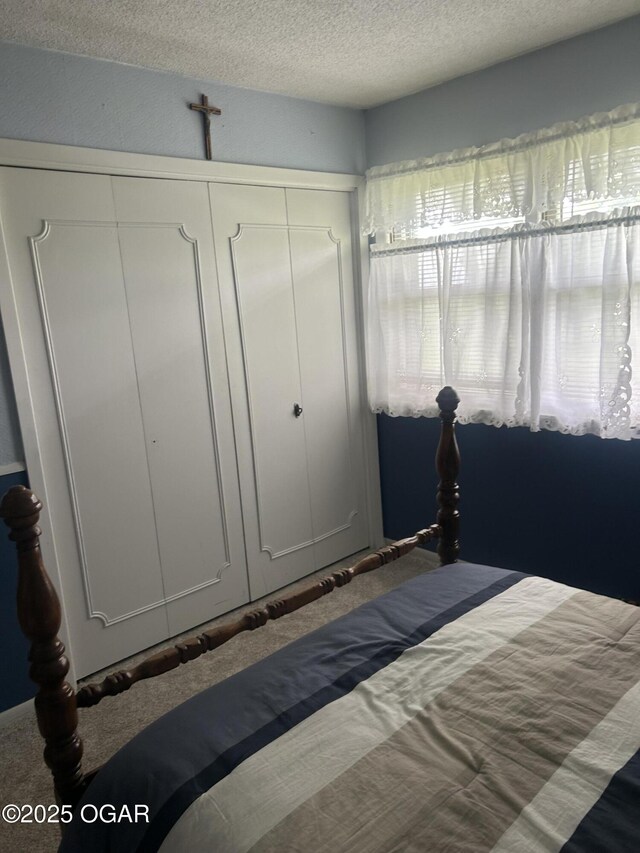 bedroom featuring a textured ceiling and carpet flooring