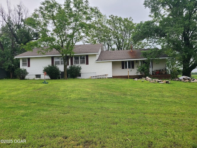 back of property featuring a yard and roof with shingles