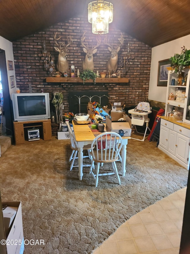 dining room with lofted ceiling, brick wall, wooden ceiling, a chandelier, and a fireplace
