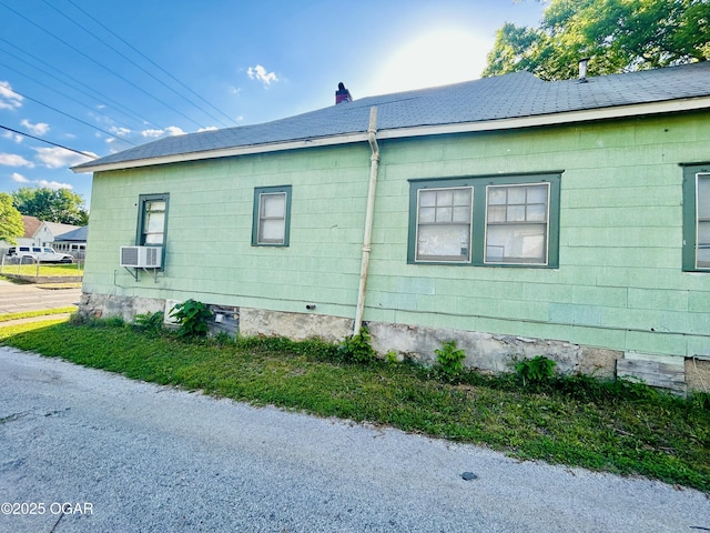 view of property exterior featuring a chimney and cooling unit