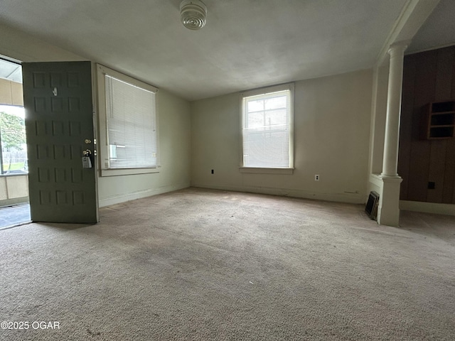 915 W 8th St, Joplin, MO 64801 - unfurnished living room with ornate columns, lofted ceiling, carpet floors, and baseboards