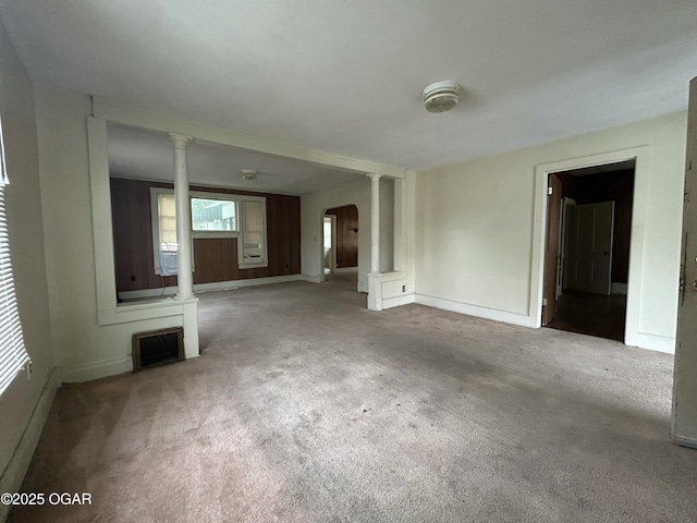 915 W 8th St, Joplin, MO 64801 - unfurnished living room featuring carpet flooring, decorative columns, arched walkways, and baseboards