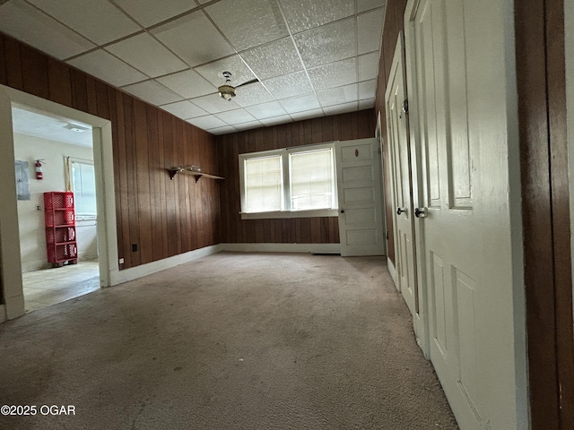 915 W 8th St, Joplin, MO 64801 - empty room featuring wooden walls, light colored carpet, and a drop ceiling