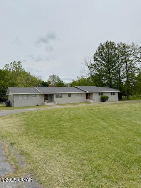 back of property featuring a lawn and driveway