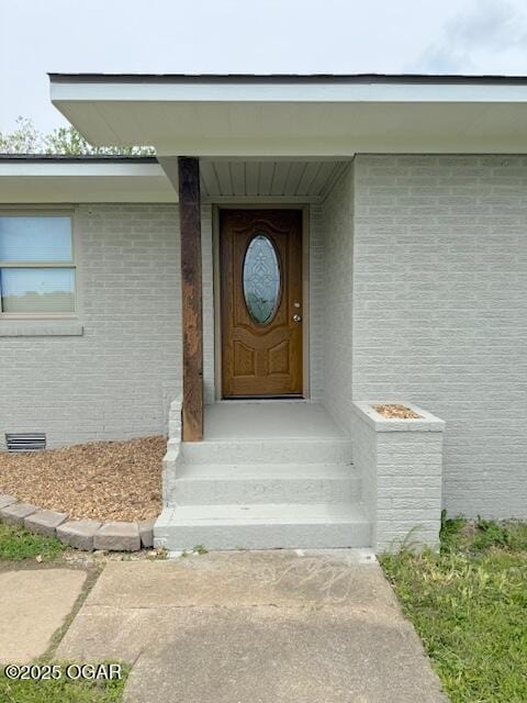 doorway to property with brick siding