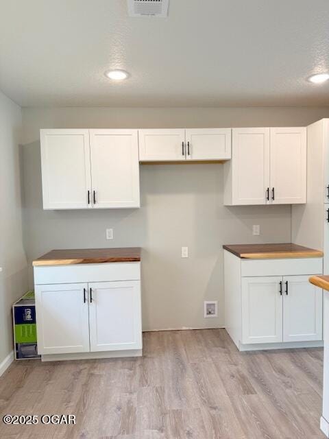 kitchen with recessed lighting, light wood-style floors, white cabinets, and visible vents