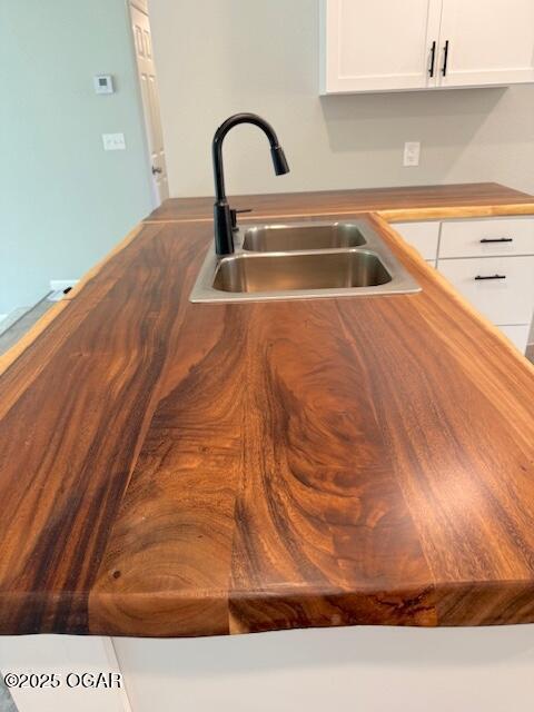 interior details with a sink and white cabinets