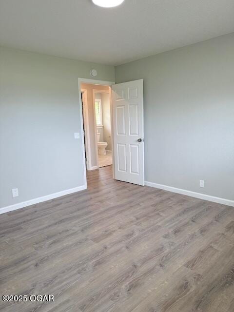 unfurnished bedroom with baseboards and wood finished floors