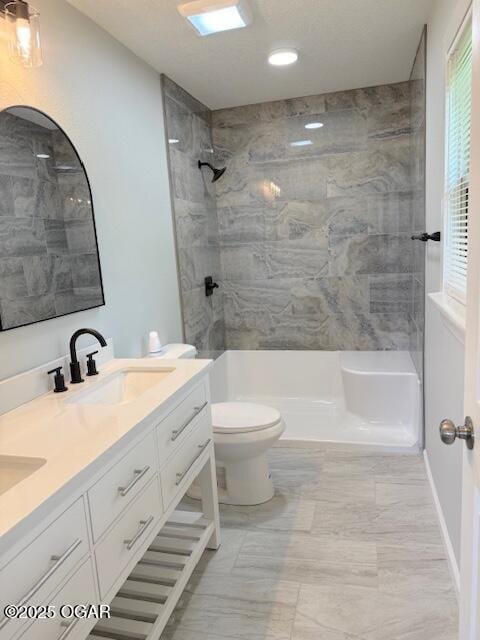 full bath with a sink, walk in shower, toilet, recessed lighting, and double vanity