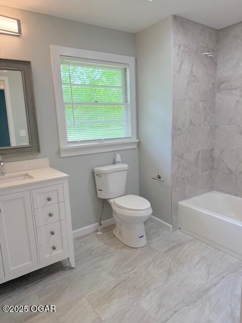 full bathroom featuring toilet, baseboards, vanity, and shower / tub combination