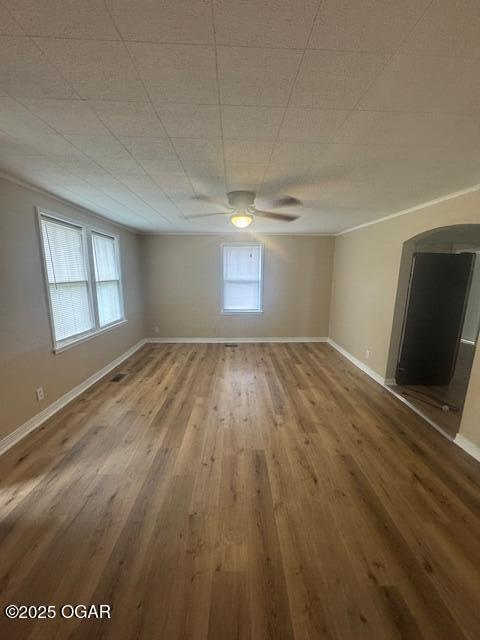 407 Porter, Joplin, MO 64801 - unfurnished room with wood finished floors, a ceiling fan, arched walkways, and baseboards