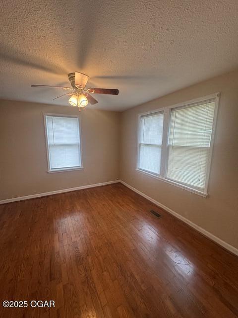 407 Porter, Joplin, MO 64801 - unfurnished room featuring wood finished floors, baseboards, a textured ceiling, a ceiling fan, and healthy amount of natural light
