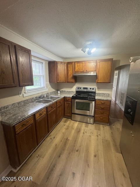 407 Porter, Joplin, MO 64801 - kitchen featuring stainless steel stove, a sink, light wood-type flooring, a textured ceiling, and brown cabinets