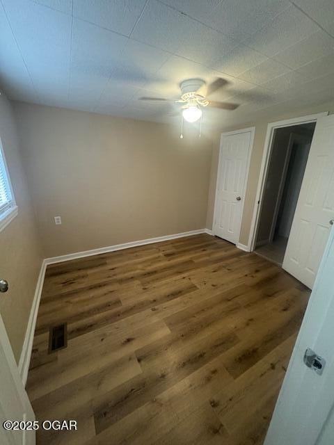 407 Porter, Joplin, MO 64801 - unfurnished bedroom with wood finished floors, a ceiling fan, and baseboards