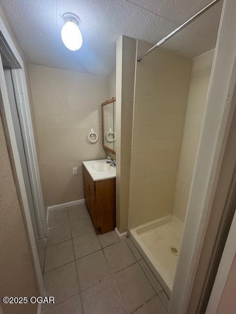 407 Porter, Joplin, MO 64801 - bathroom with tile patterned flooring, a stall shower, vanity, and baseboards
