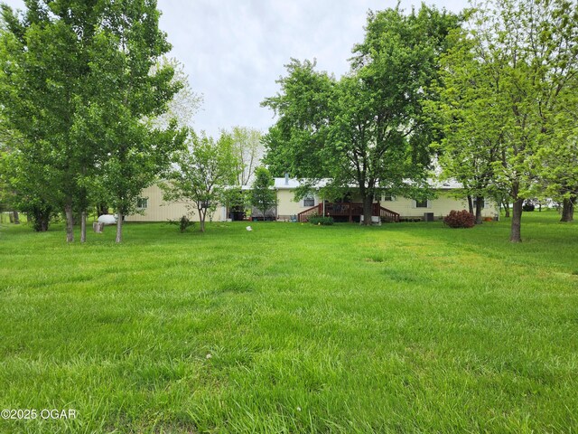 view of grassy yard featuring a deck
