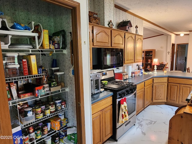 kitchen with stainless steel gas stove, black microwave, wallpapered walls, light marble finish floors, and ornamental molding