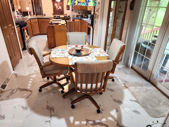 dining area featuring light marble finish floors