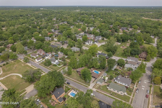 aerial view of property's location featuring a forest and nearby suburban area