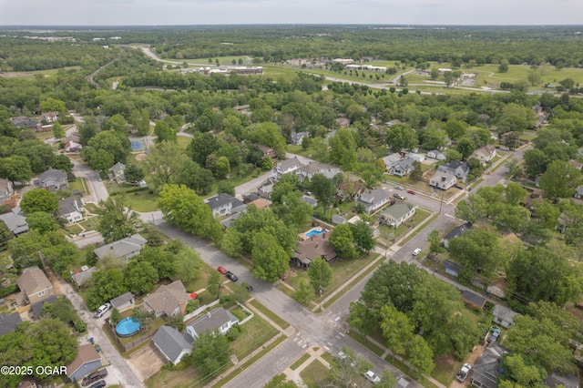 view of property location with nearby suburban area and a forest