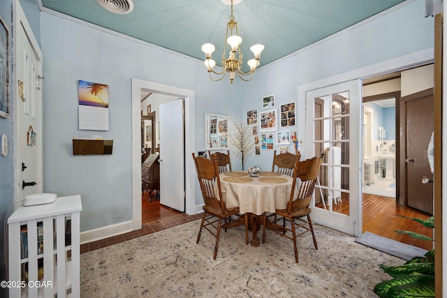 dining room featuring a chandelier and baseboards