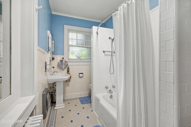bathroom featuring tile patterned floors, tile walls, toilet, crown molding, and a wainscoted wall