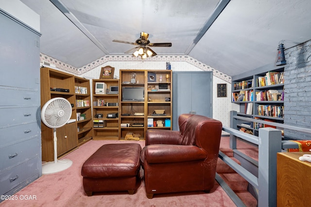 living area featuring vaulted ceiling, carpet flooring, and ceiling fan