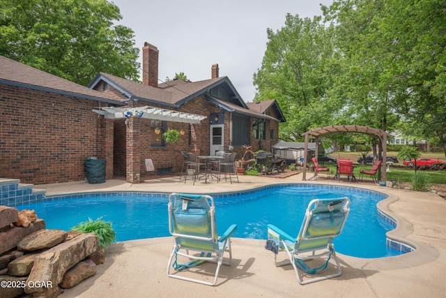 swimming pool featuring a pergola, a patio area, and outdoor dining space