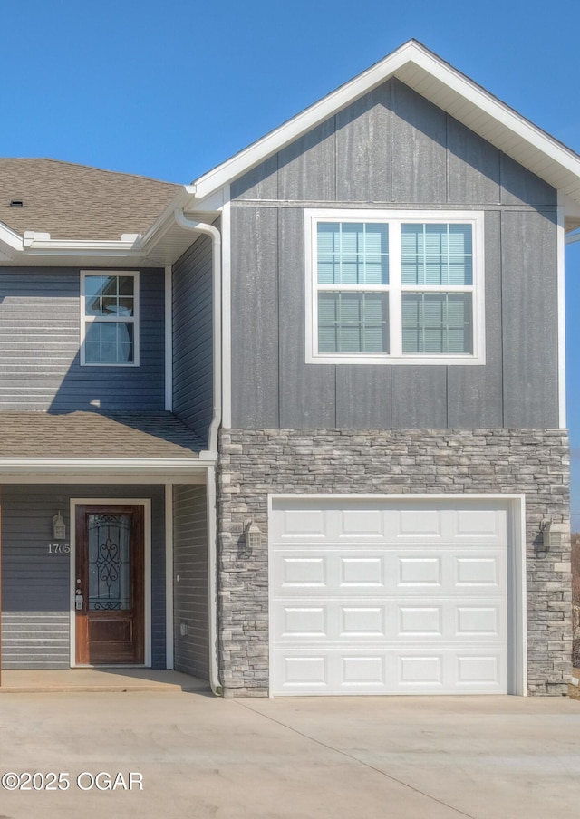 craftsman inspired home with stone siding, an attached garage, concrete driveway, and board and batten siding