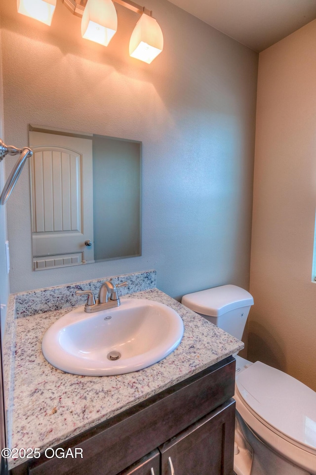 bathroom with toilet and vanity