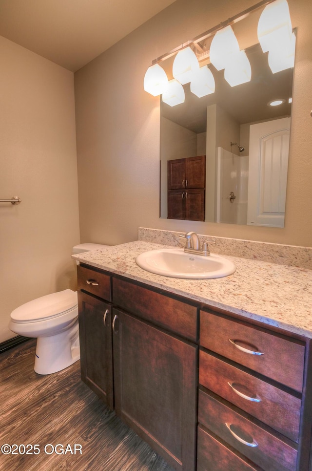 bathroom with wood finished floors, a shower, vanity, and toilet