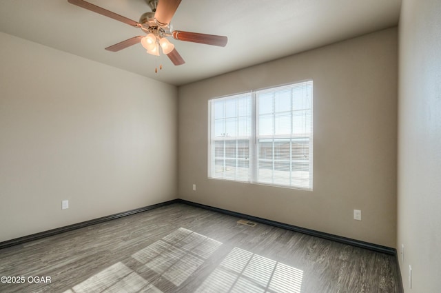 spare room featuring wood finished floors, a ceiling fan, and baseboards