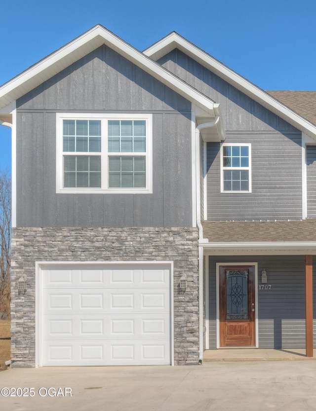 craftsman-style home with stone siding, driveway, an attached garage, and roof with shingles