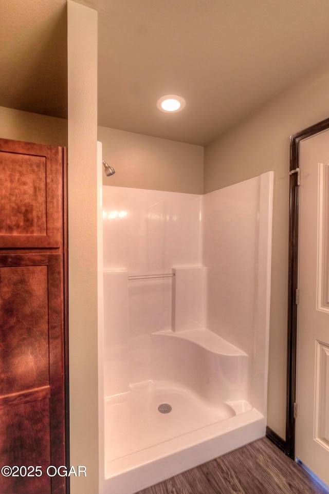 full bath featuring a shower and wood finished floors