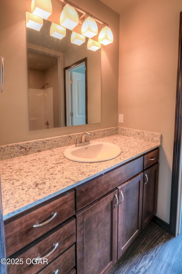 bathroom with vanity, wood finished floors, and a shower