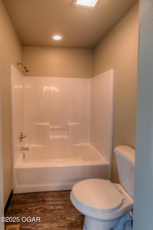 bathroom with toilet, wood finished floors, bathtub / shower combination, and recessed lighting