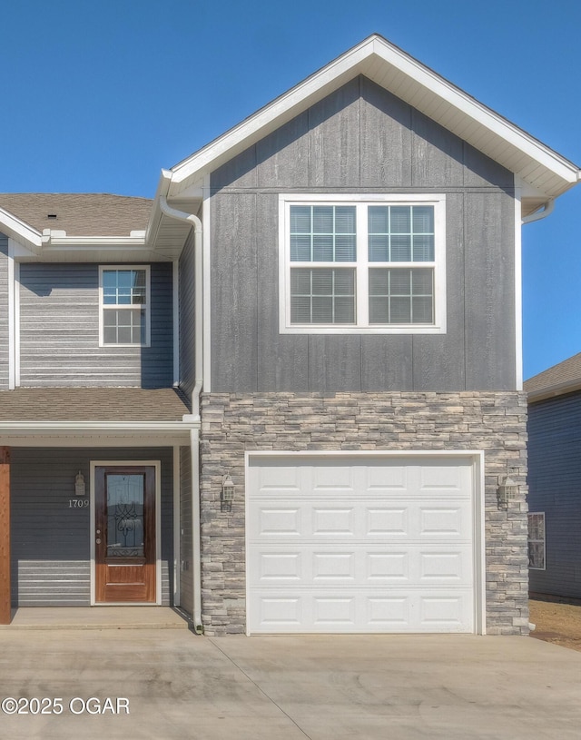 craftsman-style house with stone siding, driveway, an attached garage, and a shingled roof