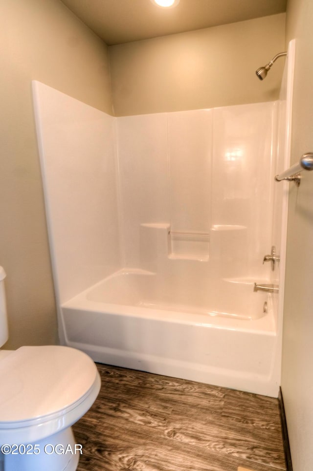 full bathroom featuring wood finished floors, shower / bathtub combination, and toilet