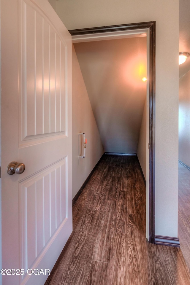 corridor with dark wood-style floors and lofted ceiling